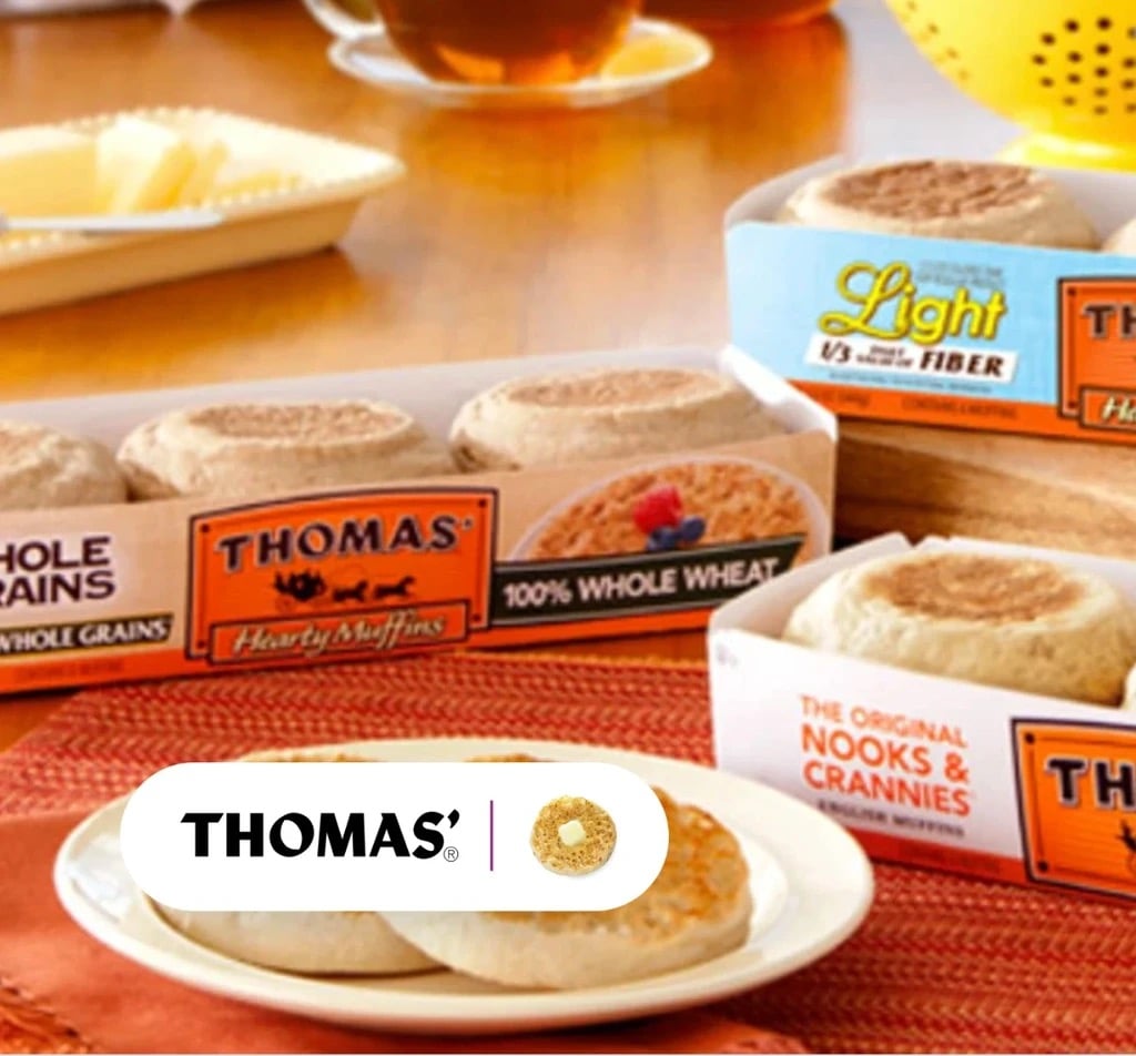 Several types of Thomas' English Muffins in supermarket packaging on a table.